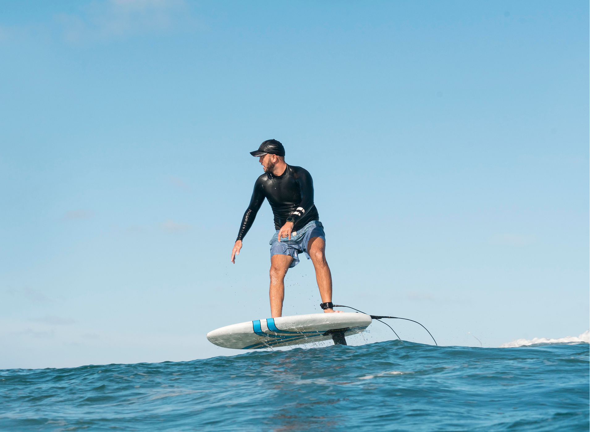 Rider on an e-foil surfboard hovering above the water