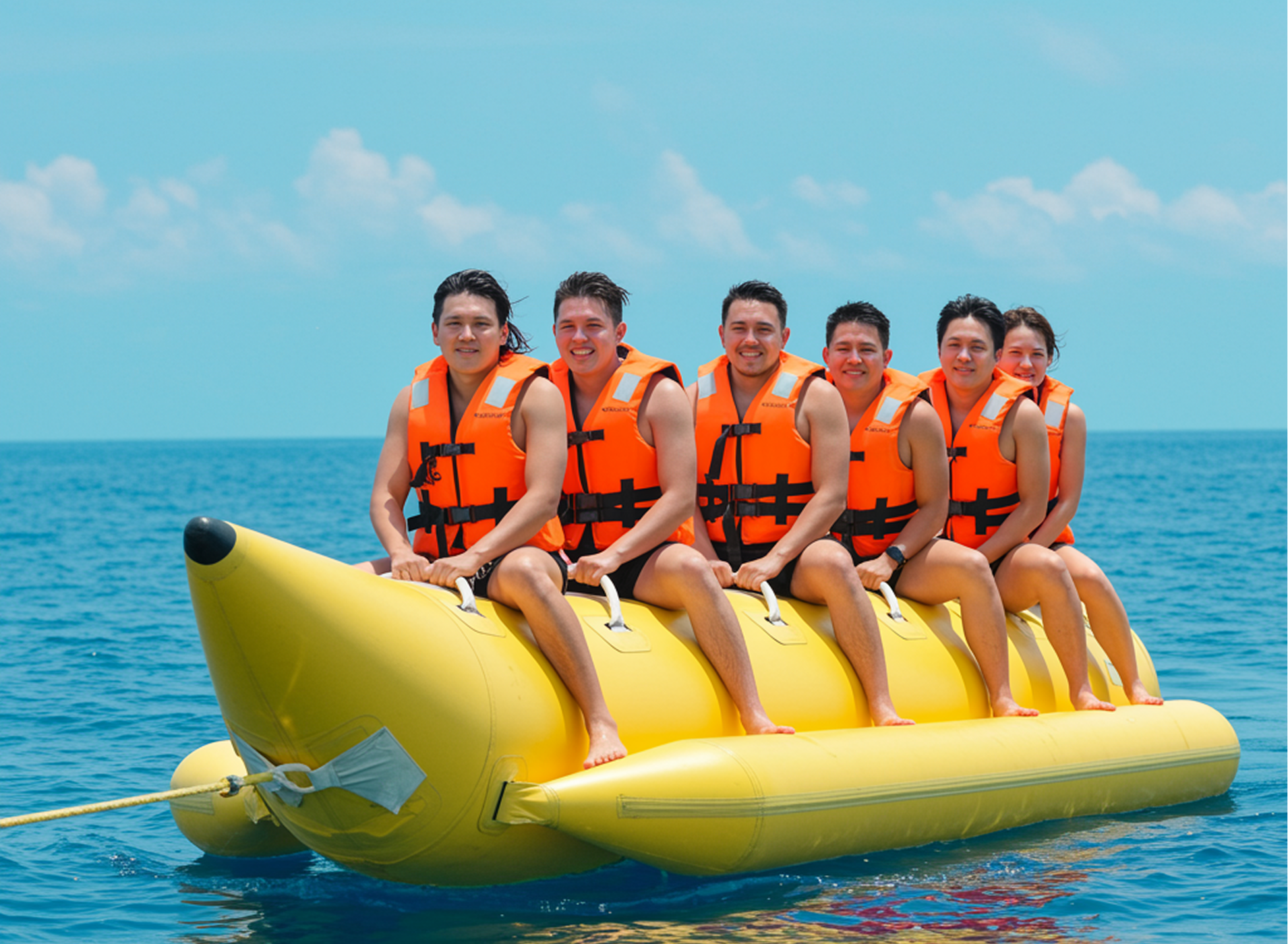 Six guests riding a banana boat inflatable