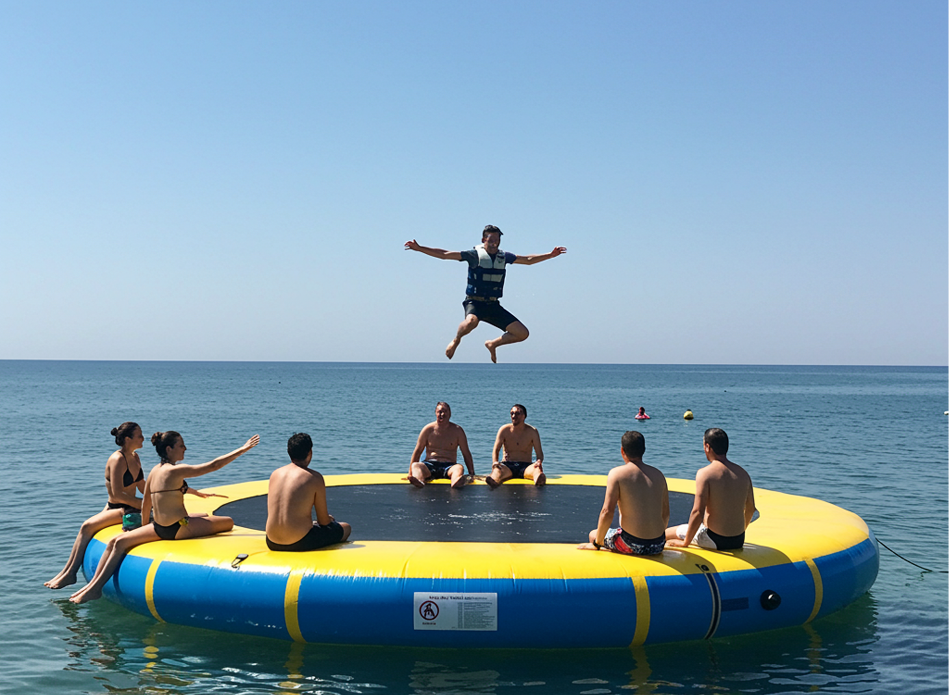 Guests jumping on a floating water trampoline